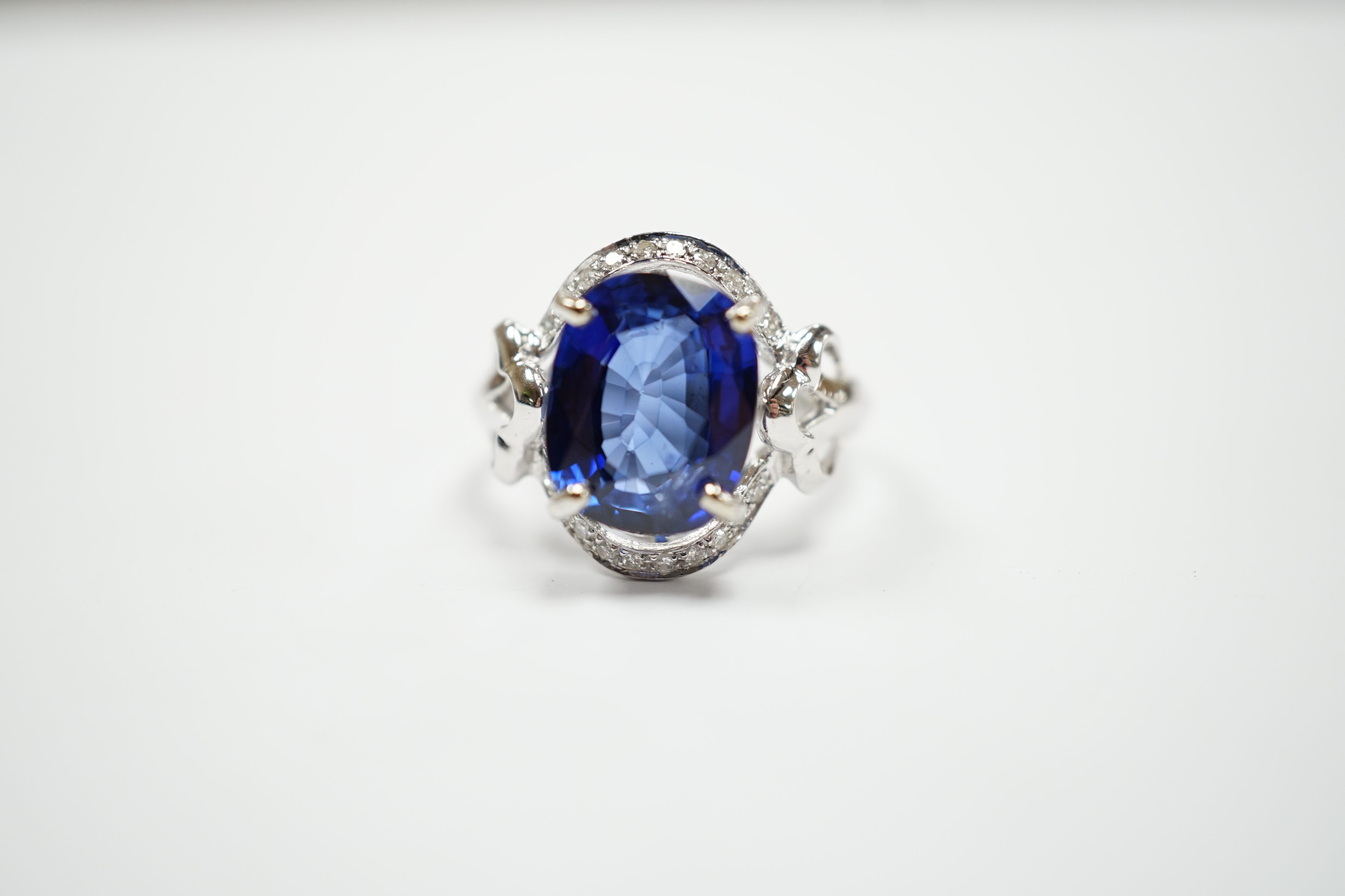 A modern 10k white metal, sapphire and diamond chip set oval cluster set dress ring, size M, gross weight 3.7 grams.